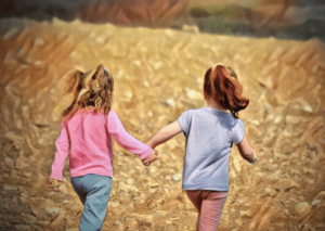two young girls holding hands outside in park