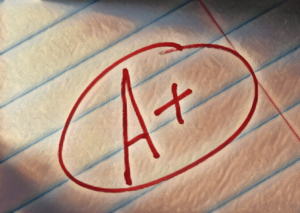 Red "A+" grade on lined paper