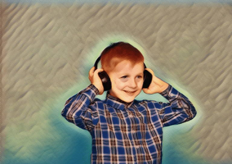 young boy wearing headphones with hands on ears