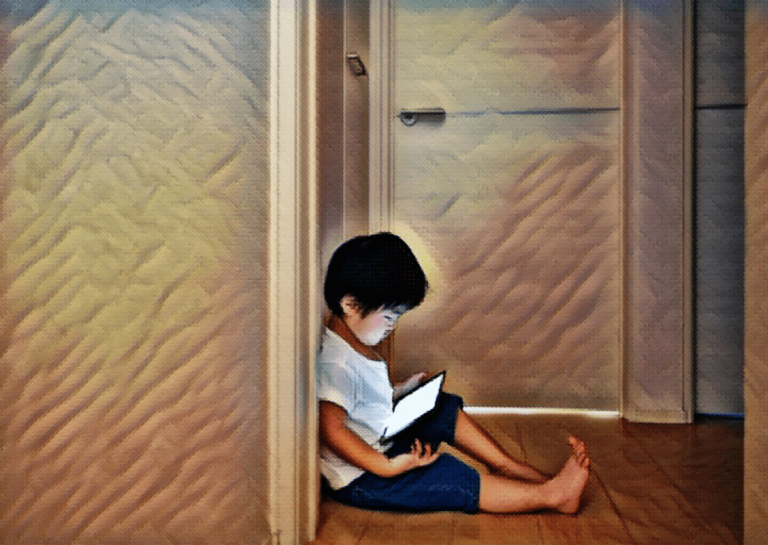 young boy sitting in hallway with tablet