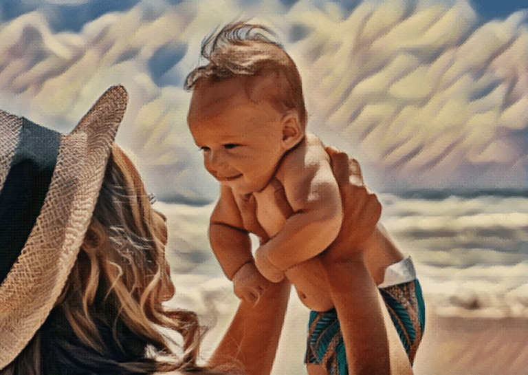 mother holding up newborn infant toddler on sunny beach day